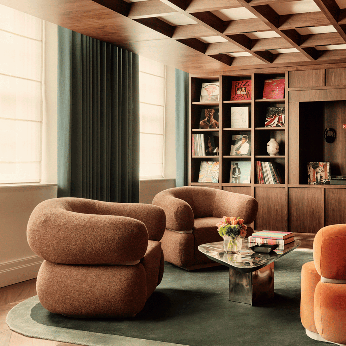 Malibu Armchair pair in brown Bouclé in a wood-panelled library with a green rug