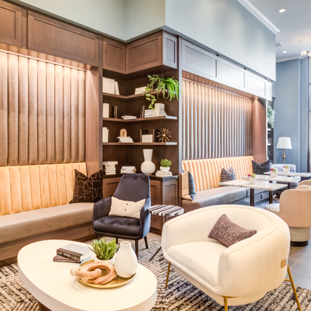Blop Armchair in cream bouclé in a lounge with wood panelling and banquettes