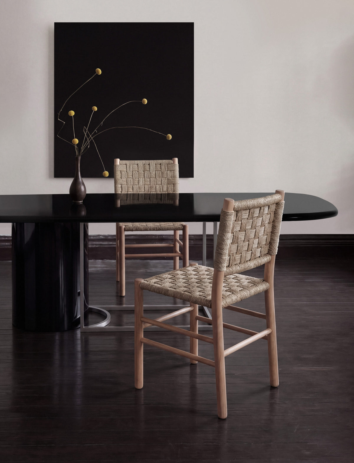 Horus Dining Table in black gloss lacquer with woven rush chairs in a dark dining room