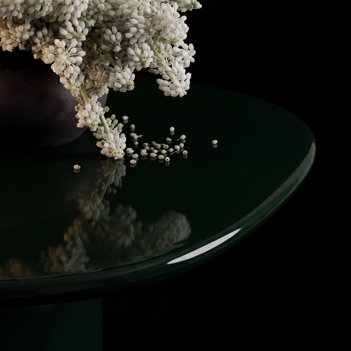 Horus Dining Table, detail of the glossy green top reflecting a flower arrangement