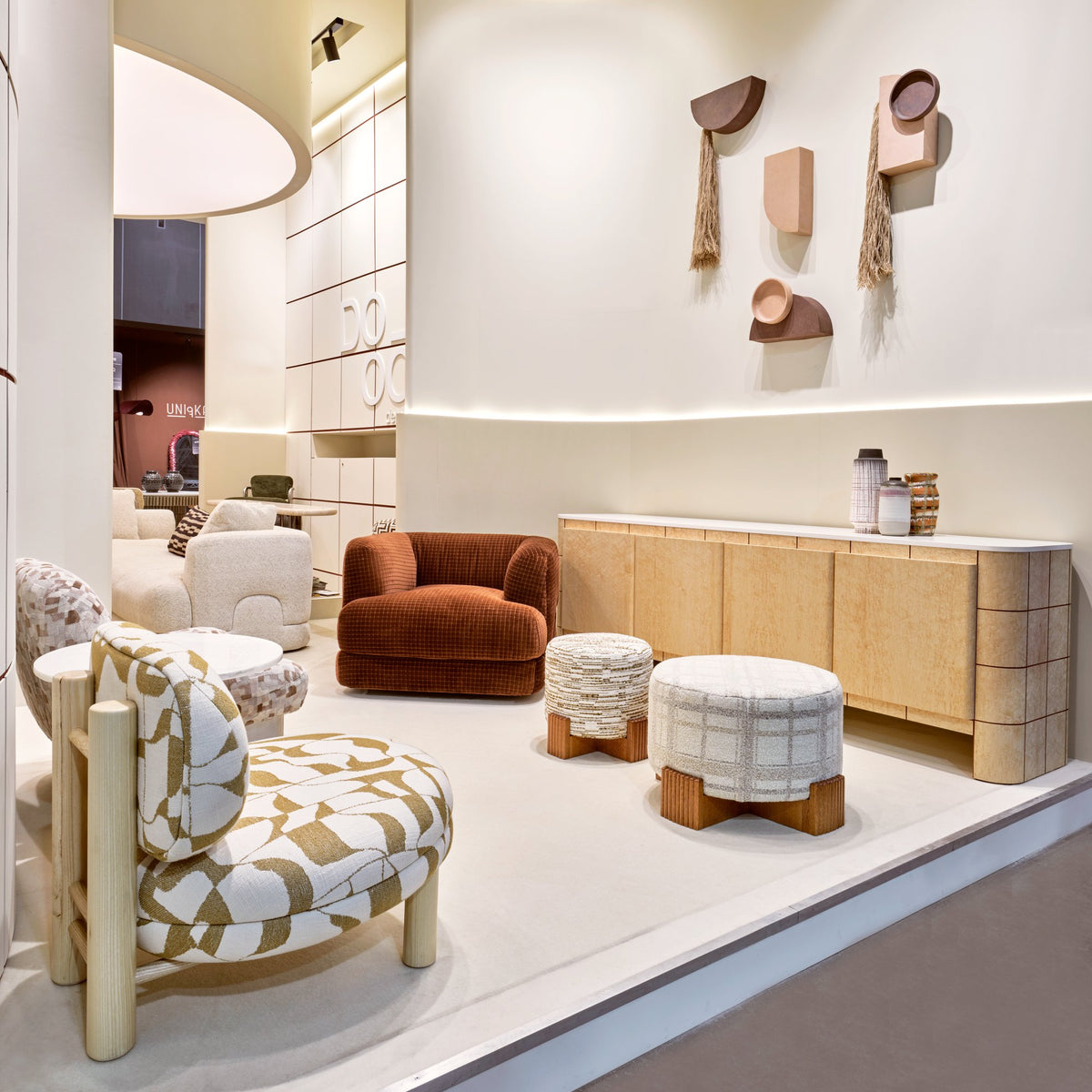 Twin Ottoman pair in a showroom with patterned lounge chair and sideboard