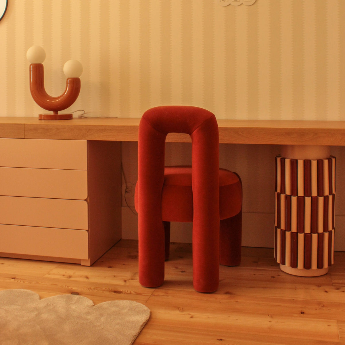 Marlon Chair in rust velvet at a wooden vanity desk with striped walls