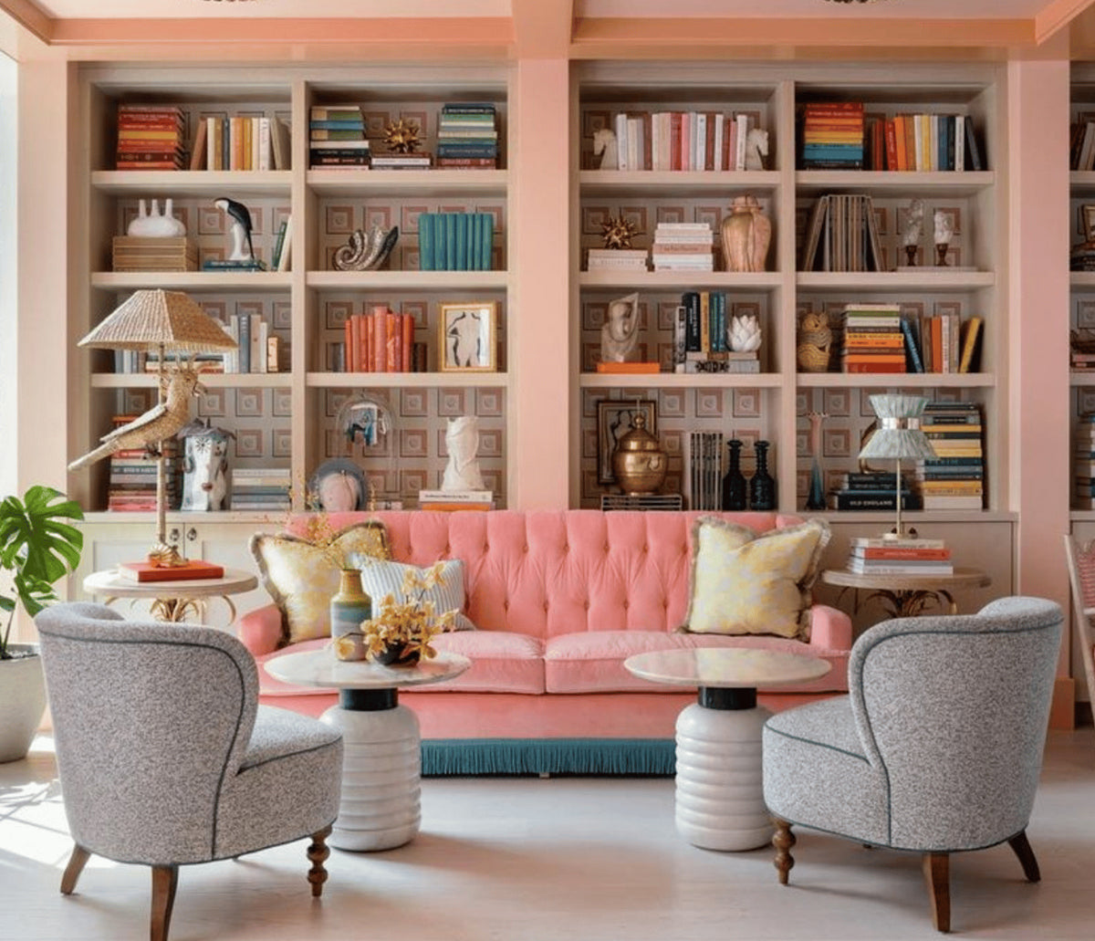 Jean Side Tables beside grey armchairs and a pink tufted sofa in a library lounge