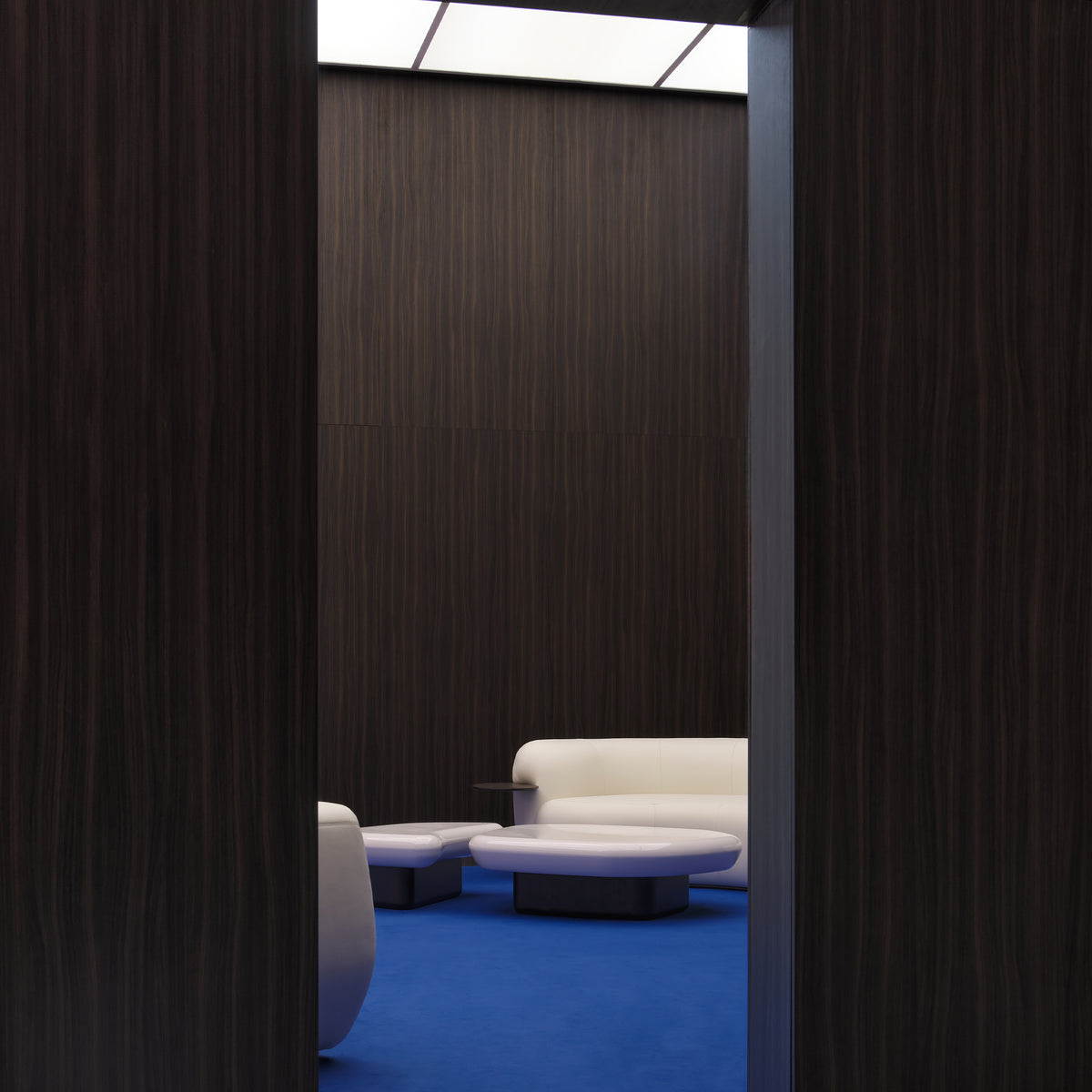 Kawa Coffee Tables in a dark panelled room with white sofas, right view