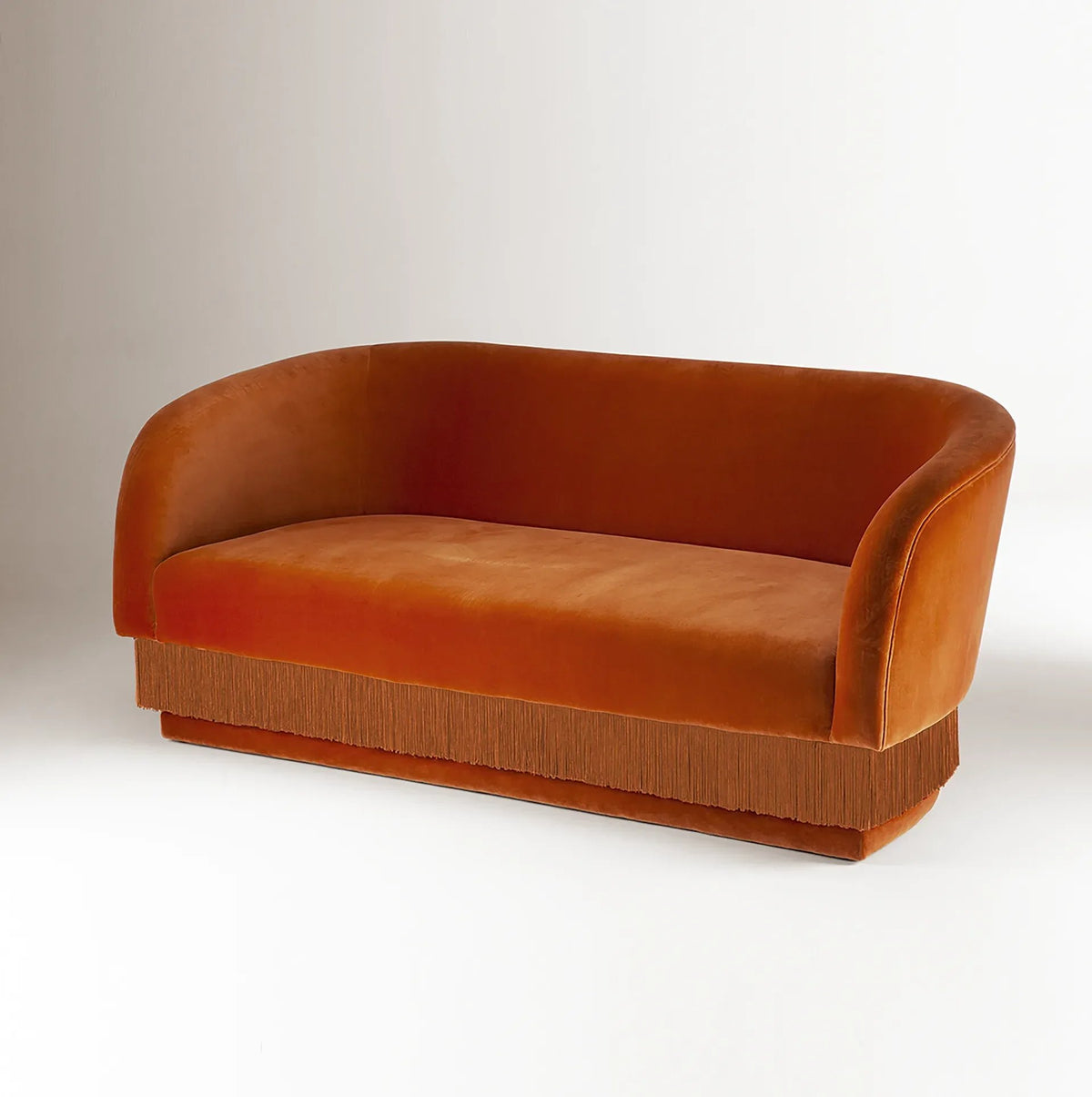La Folie Sofa in burnt orange velvet with matching fringe, front view