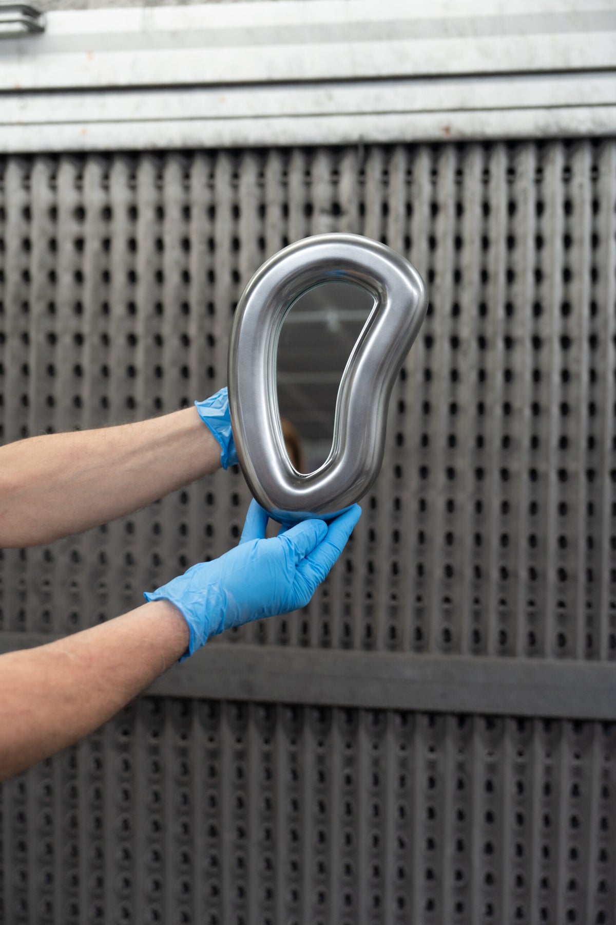 Laghi Mirrors single polished silver mirror held up by gloved hands