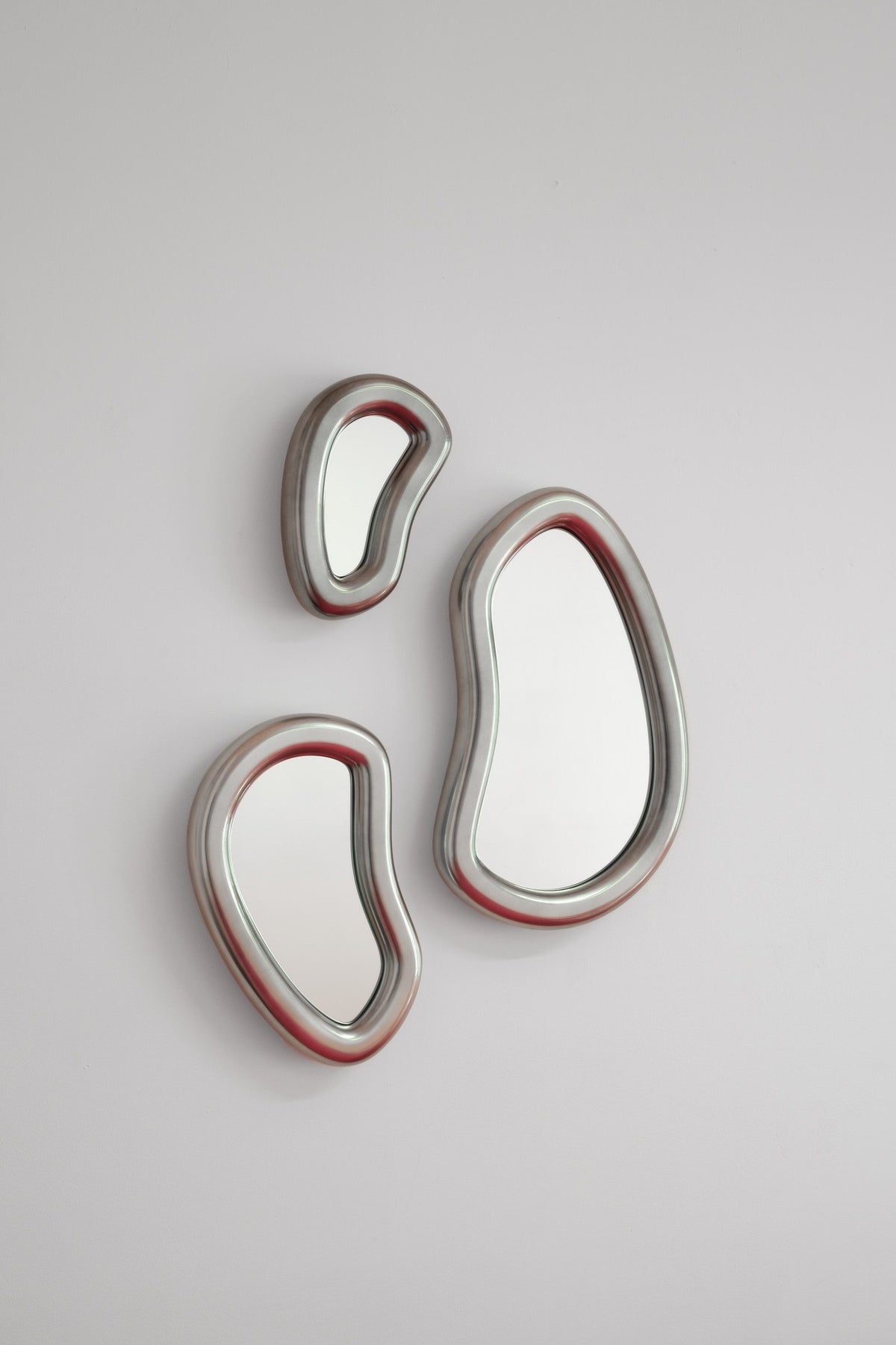 Laghi Mirrors trio in silver with red edge accents on a grey wall