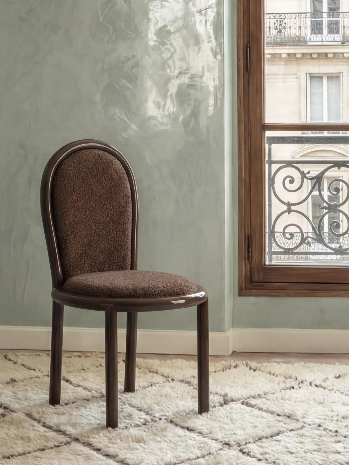 Masa Dining Chair in dark wood and brown upholstery by a window on a shag rug