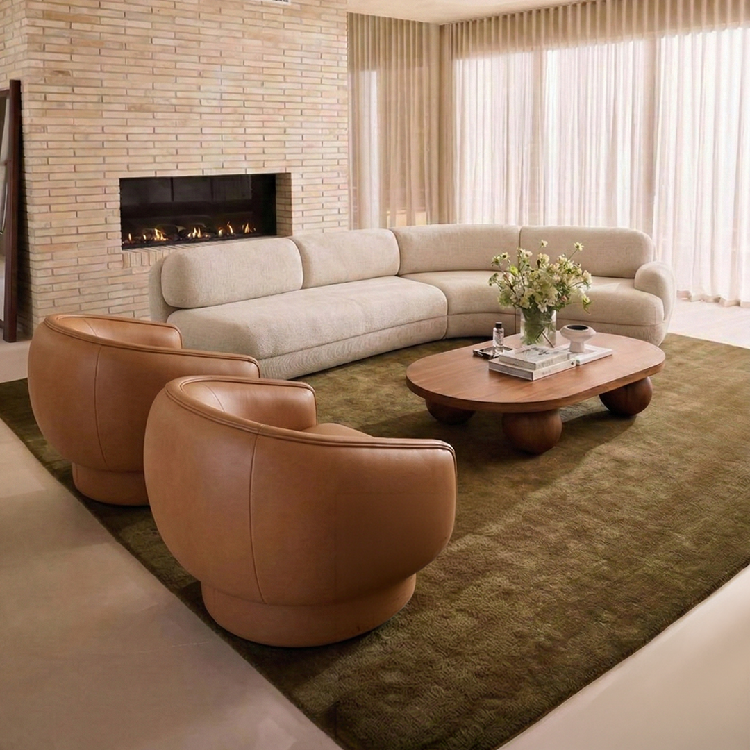 Moon Swivel Armchair pair in tan leather with a cream sofa and green rug