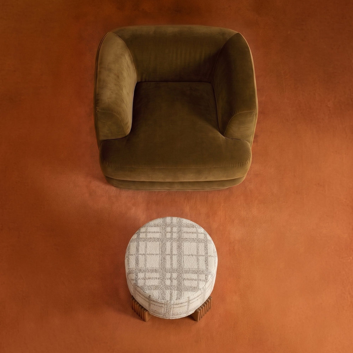 Mosaico Armchair in olive velvet from above with a plaid ottoman on an orange rug