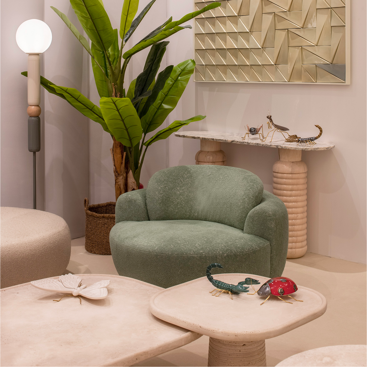 Naked Armchair in sage green Bouclé in a showroom with a banana plant and stone tables