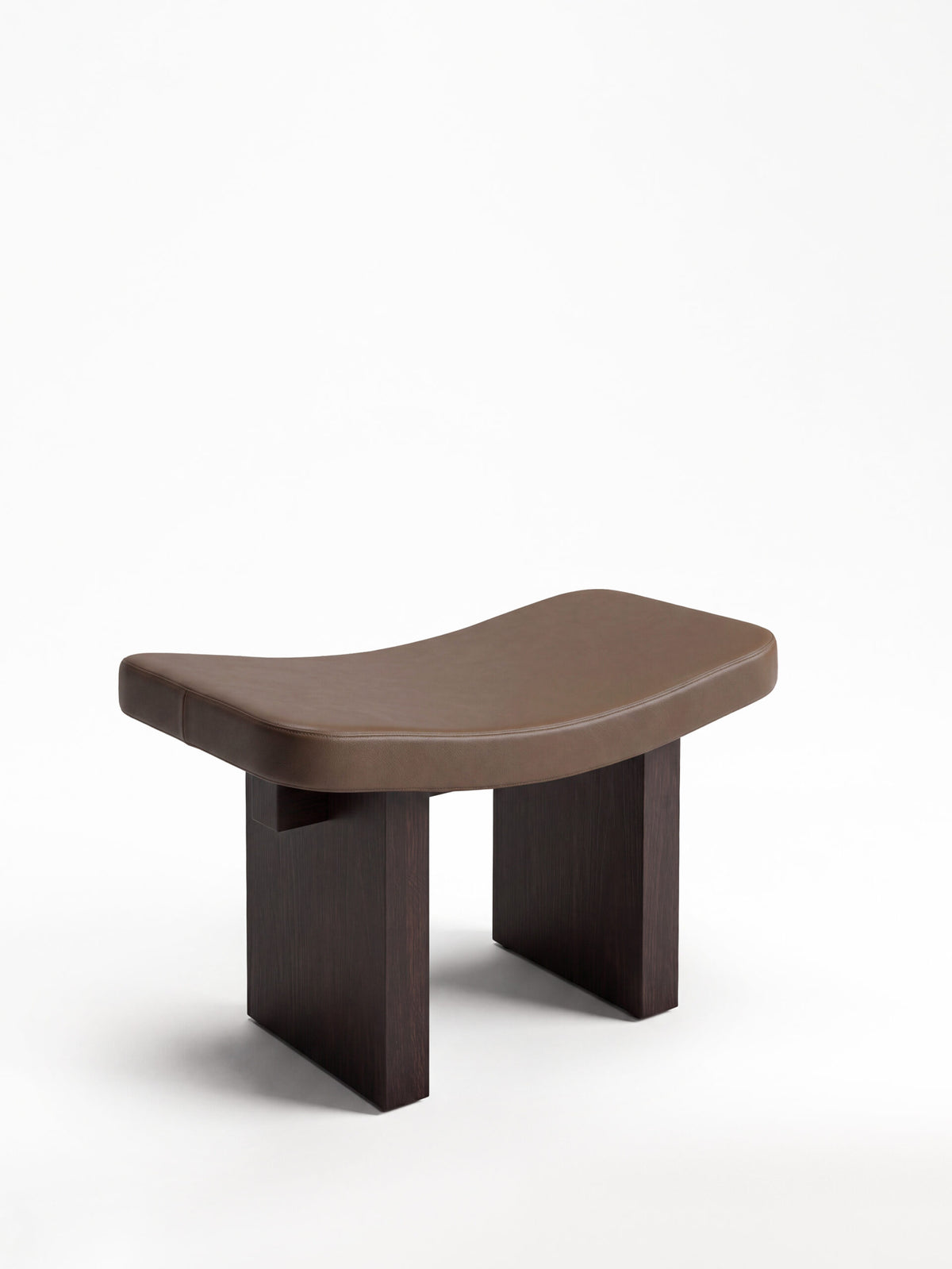 Nara Ottoman in brown leather with dark wood legs, front three-quarter view