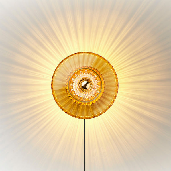 New Wave Optic Wall Sconce in amber glass with eyeball, lit with ray pattern and black cord