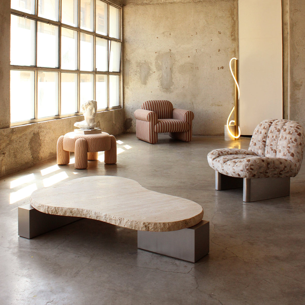 On The Rocks Coffee Table with satin nickel base in a loft with patterned lounge chairs