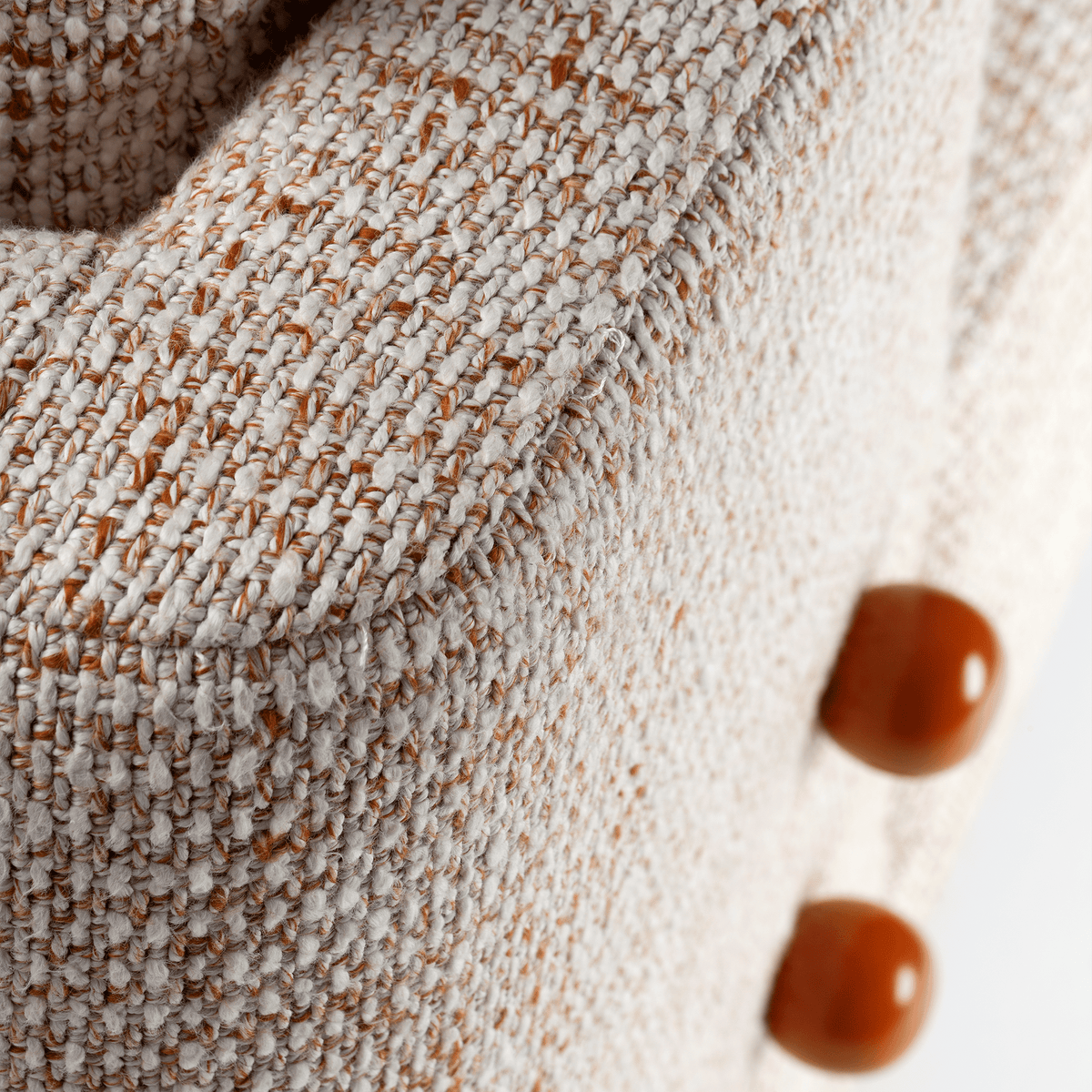 Panorama Armchair close-up of glossy amber buttons on speckled bouclé