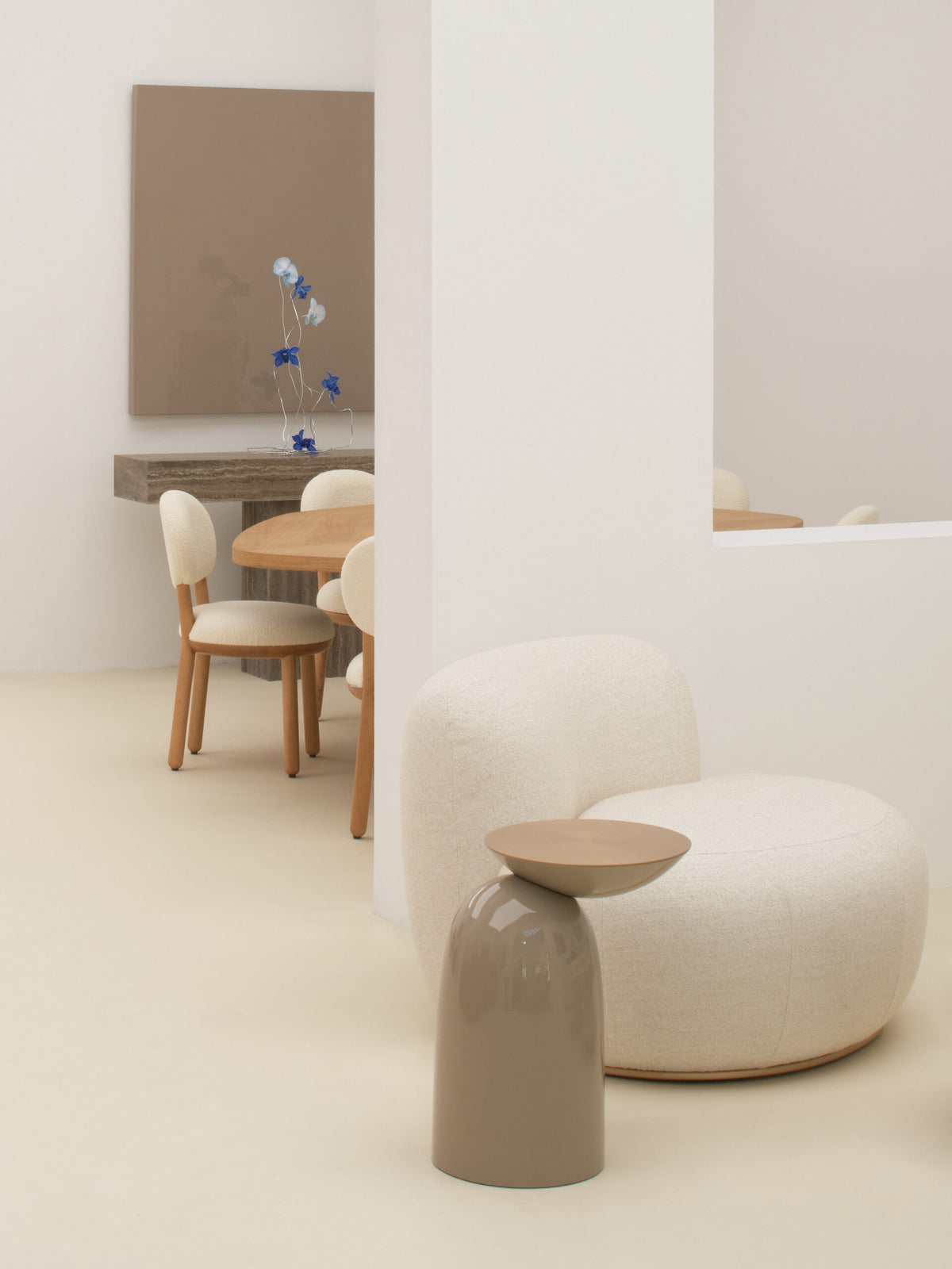 Pingu Side Table in taupe lacquer beside a white bouclé chair in a bright room