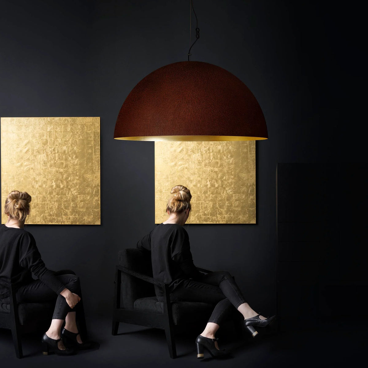 Mammalampa Queen Pendant Light, large rust dome hung in a dark room with gold wall panels