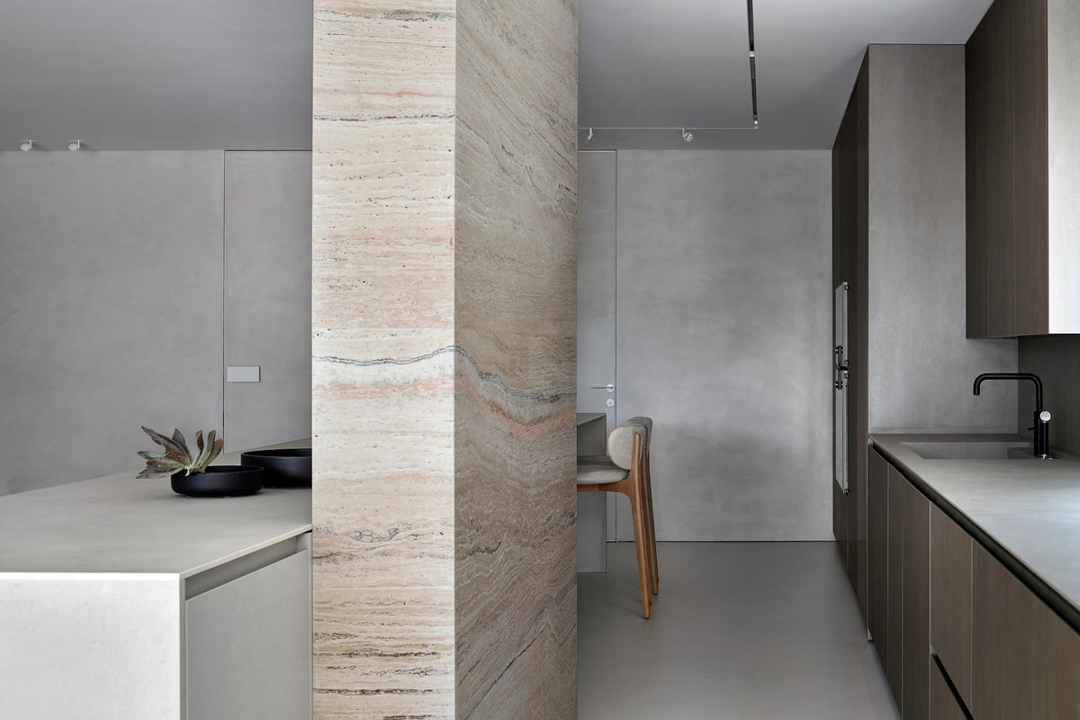 Richmond Bar Stool beside a travertine column in a modern kitchen