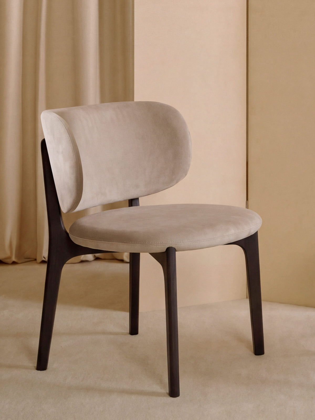 Richmond Lounge Chair in taupe before a pleated beige curtain
