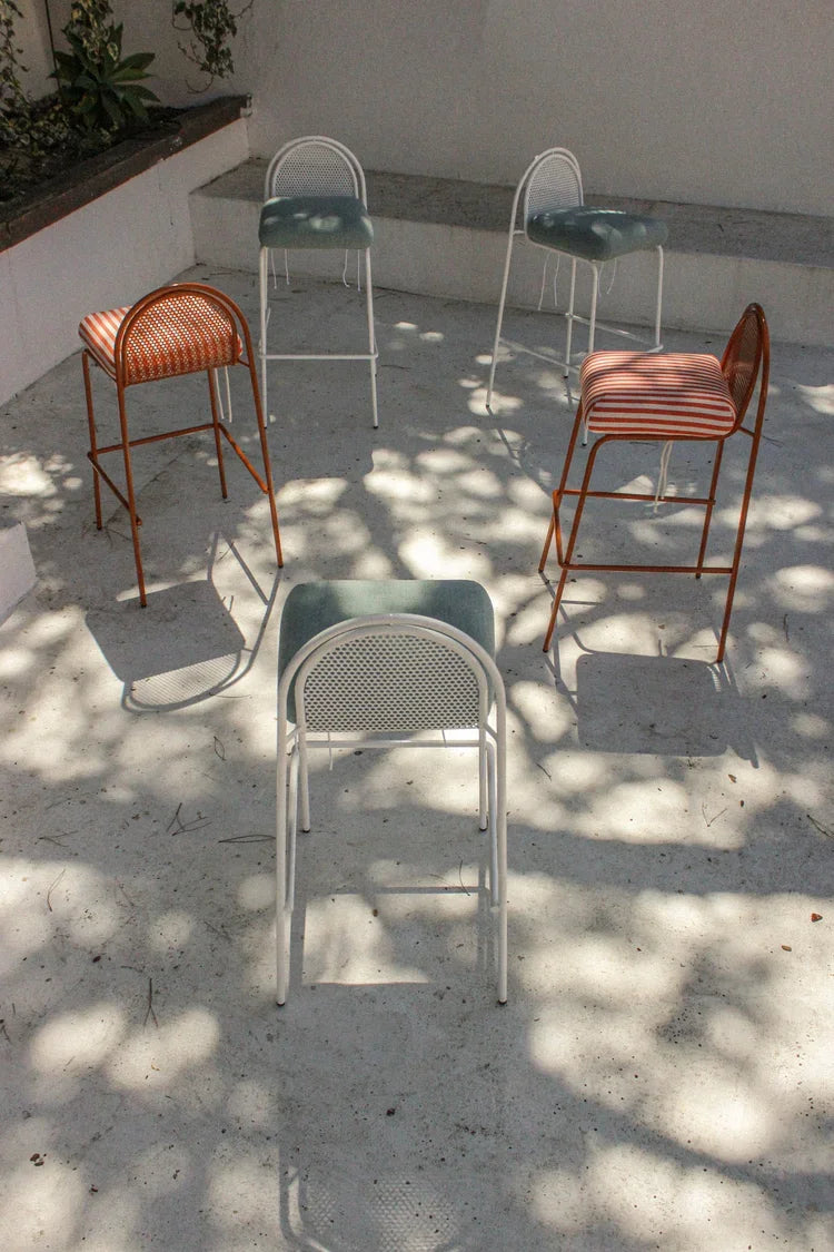 Riviera Bar Chair set in several colours on a sun-dappled terrace