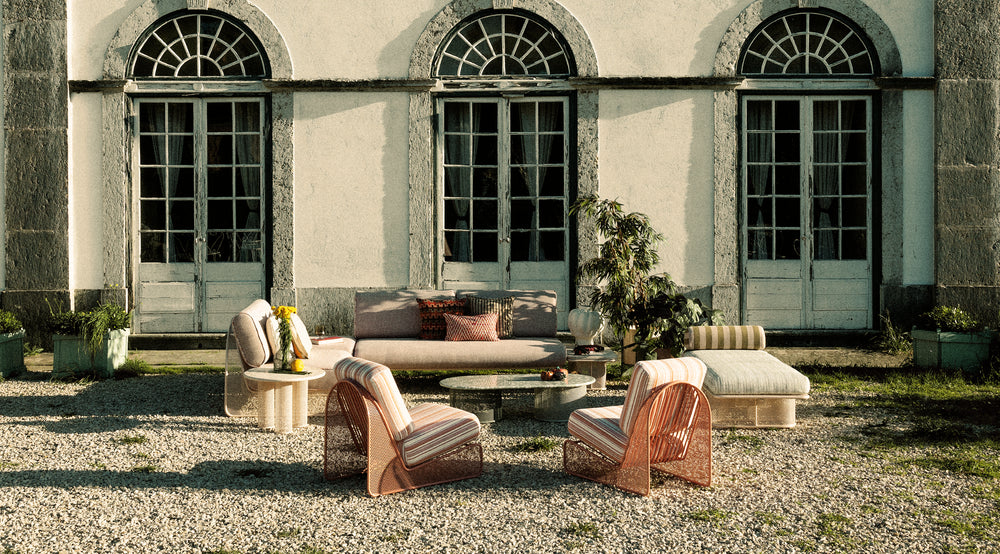 Riviera Modular Sofa - 1 Seat in blush pink outdoor set on gravel before an arched villa facade