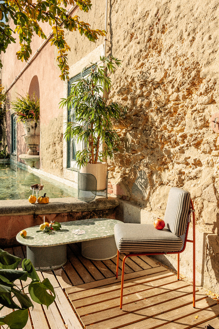 Riviera Vases on a sunny stone patio with a lounge chair and table