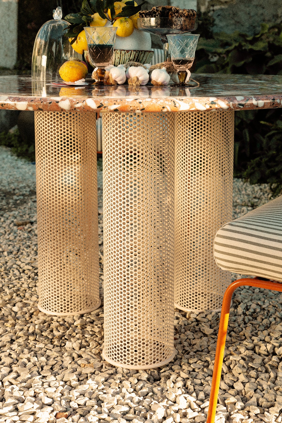 Riviera Dining Table base detail on gravel with striped chair