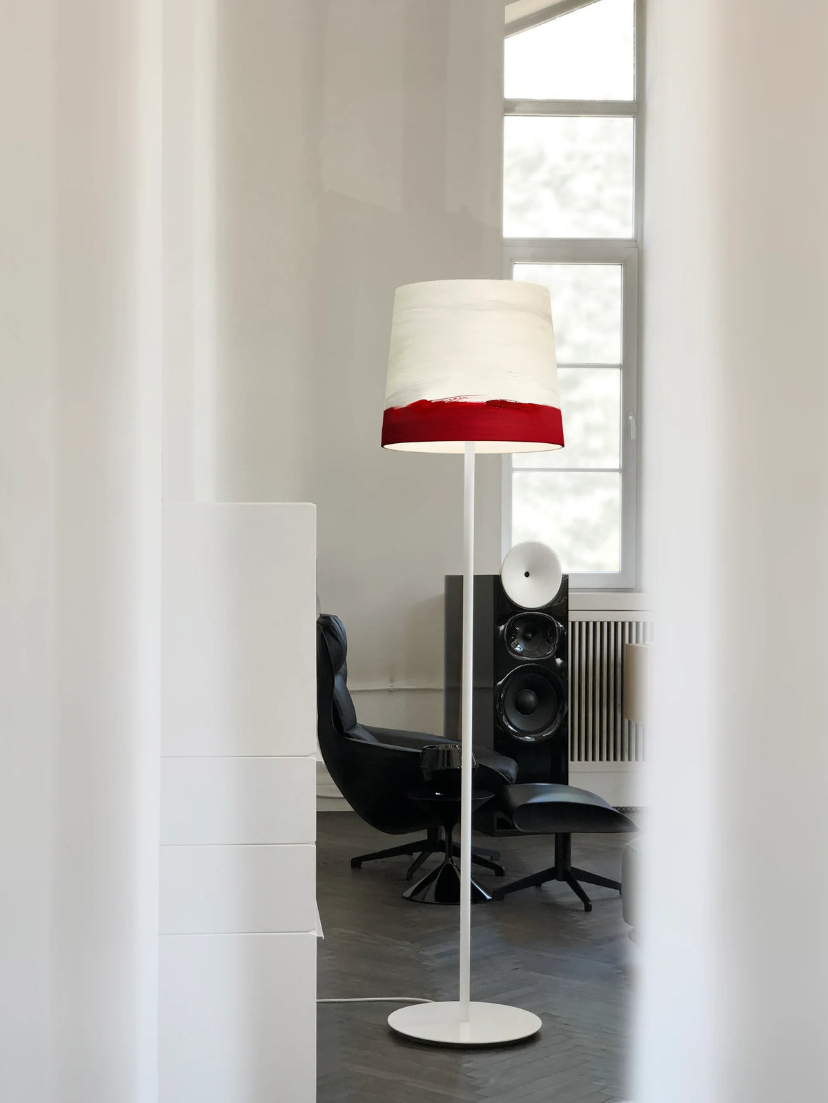 Mammalampa Sisters Floor Lamp in Sunrise in a bright room beside a black lounge chair
