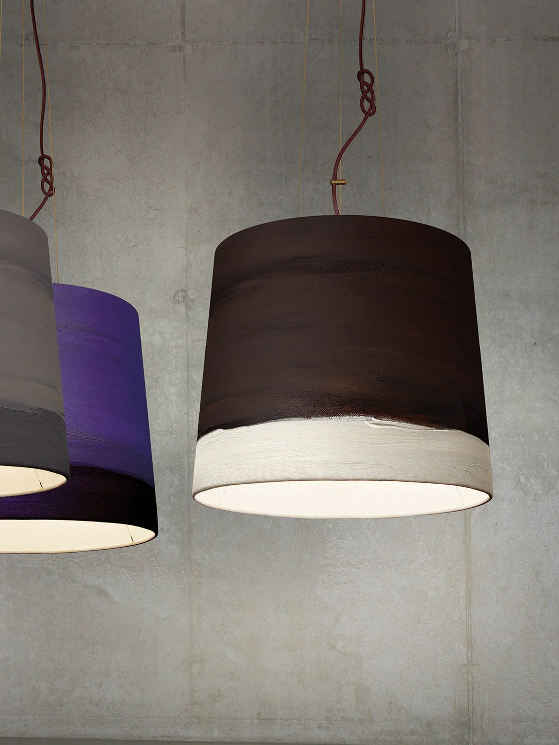 Mammalampa Sisters Pendant Light Medium in Noon, dark brown shade with white band against a concrete wall