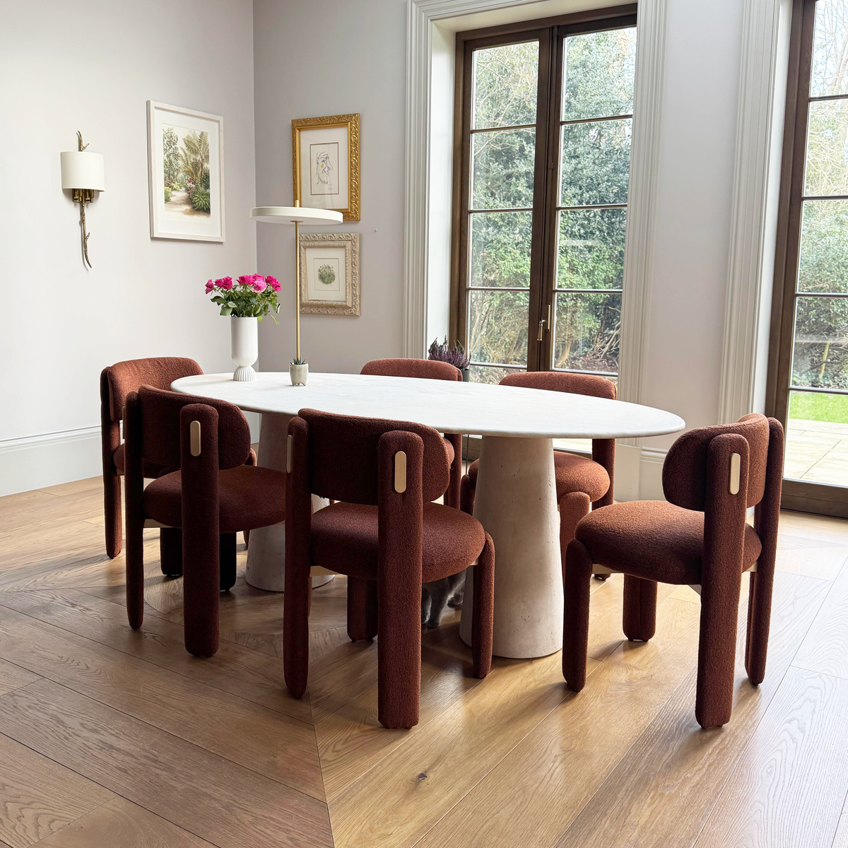 Choux Dining Chair set in burgundy around an oval white dining table