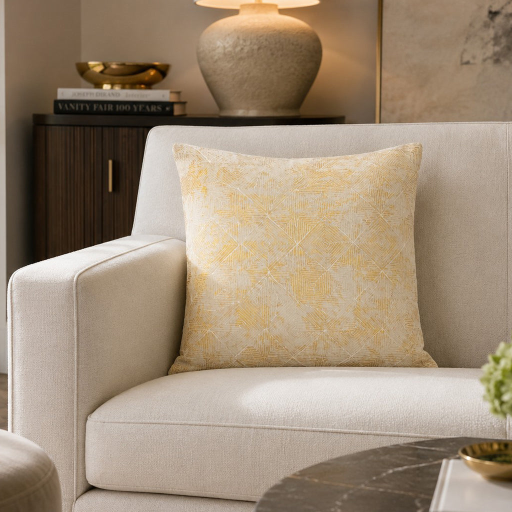 Verona Gold Dori Pillow on a cream armchair beside a marble coffee table
