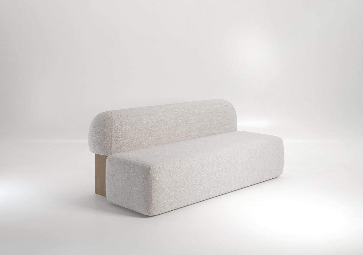 Yemeni Sofa in cream Soft Bouclé with wood plinth, angled on white