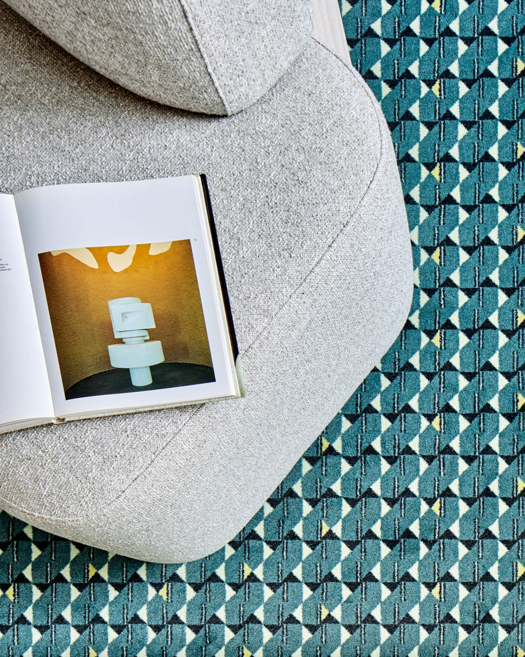 Yoshida Lounge Chair in light grey, overhead view of the seat on a teal geometric rug