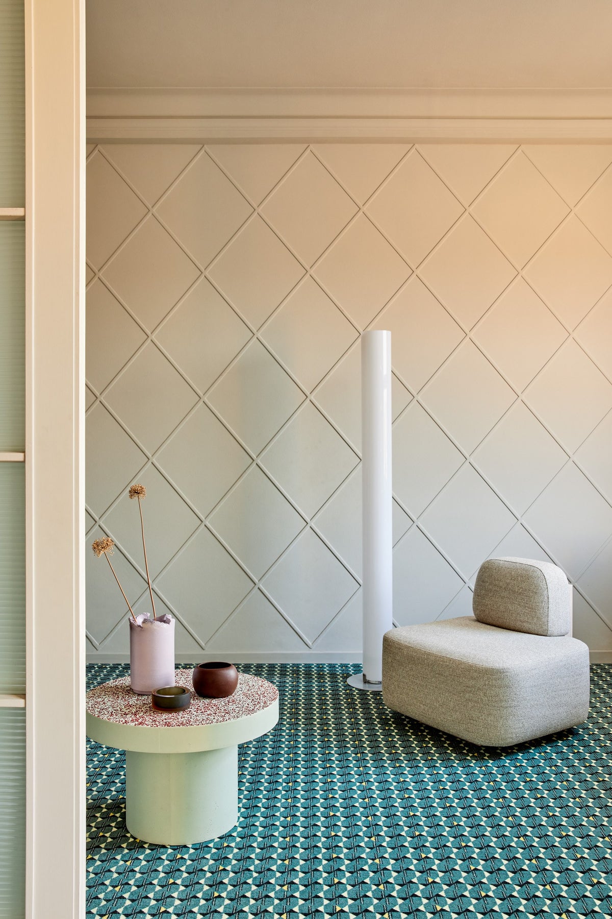 Yoshida Lounge Chair in cream with a round side table in a room with green patterned floor
